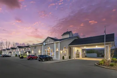 a large building with cars parked in a parking lot at Best Western Cooperstown in Cooperstown