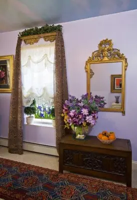 a room with a mirror and a table with flowers at Beds on Clouds in Windham