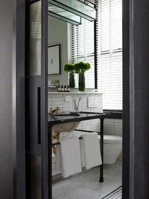 a bathroom with a sink and a toilet and a mirror at Refinery Hotel - New York in New York
