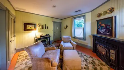 a living room with two chairs and a fireplace at The Porches Inn at Mass MoCA in North Adams