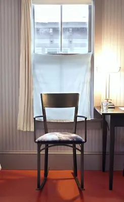 a chair in a room with a desk and a window at The Porches Inn at Mass MoCA in North Adams