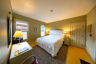 a bedroom with a large white bed and a window at The Porches Inn at Mass MoCA in North Adams