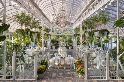 a greenhouse with tables and chairs and plants at The Madison Hotel in Morristown