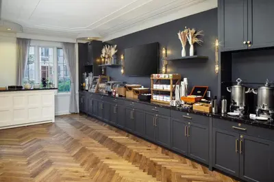 a large kitchen with black cabinets and a counter at The Madison Hotel in Morristown
