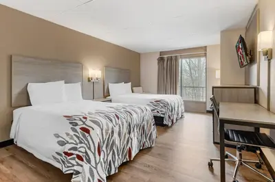 a hotel room with two beds and a desk at Red Roof Inn Stroudsburg in Stroudsburg