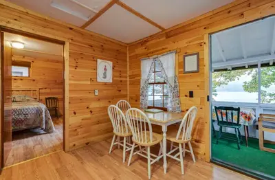 a dining room with a table and chairs at The Elms Waterfront Cottages in Lake Luzerne
