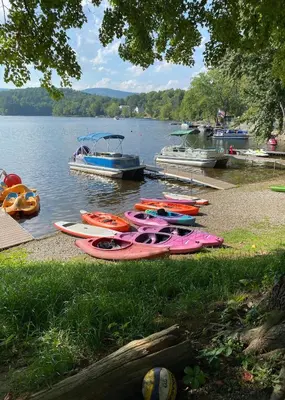 a group of kayaks parked on the shore of a lake at The Elms Waterfront Cottages in Lake Luzerne