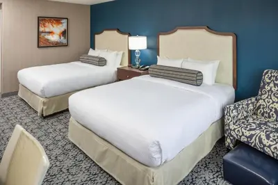 a hotel room with two beds and a chair at Inn at Middletown in Middletown