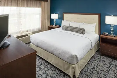 a hotel room with a large bed and a television at Inn at Middletown in Middletown