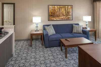 a living room with a blue couch in a hotel room at Inn at Middletown in Middletown