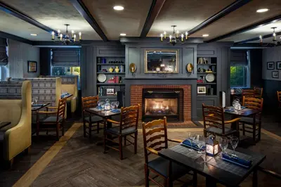 a dining room with tables and a fireplace at Inn at Middletown in Middletown