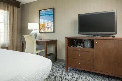 a hotel room with a bed and a flat screen tv at Inn at Middletown in Middletown