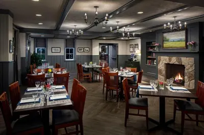 a restaurant with tables and chairs and a fireplace at Inn at Middletown in Middletown