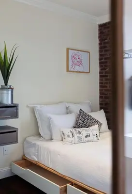 a bed with white pillows in a room at East Village Hotel in New York