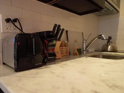 a toaster sitting on a kitchen counter next to a sink at East Village Hotel in New York