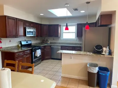 a kitchen with wooden cabinets and a counter top at Business & Family Friendly Balcony Jacuzzi Free Park in Jersey City