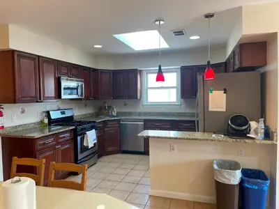a kitchen with wooden cabinets and a counter top at Business & Family Friendly Balcony Jacuzzi Free Park in Jersey City
