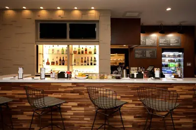 a bar in a restaurant with three chairs and a counter at Courtyard by Marriott Southington in Southington