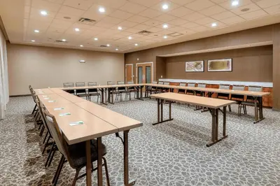 a conference room with wooden tables and chairs at Courtyard by Marriott Southington in Southington