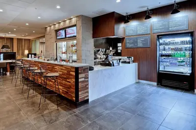 a bar in a restaurant with a counter and stools at Courtyard by Marriott Southington in Southington
