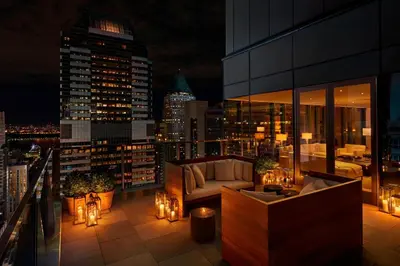 a balcony of a building with a couch and lights at The Times Square EDITION New York in New York