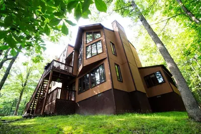 a large building with a staircase in the trees at Big House On The Hill in East Stroudsburg