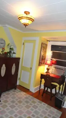 a room with a door and a table and a lamp at The Red Rooster in White Plains