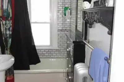 a bathroom with a tub and a sink and a toilet at The Red Rooster in White Plains