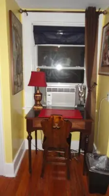 a room with a desk with a lamp and a window at The Red Rooster in White Plains