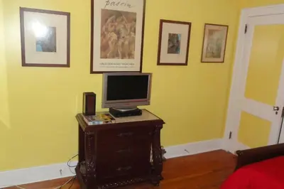 a room with a tv on a dresser with a computer on it at The Red Rooster in White Plains