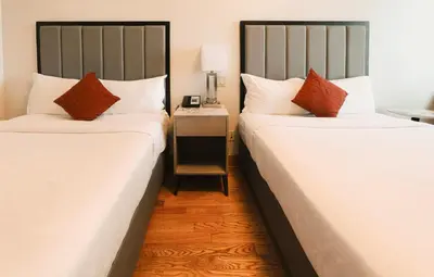 two beds sitting next to each other in a room at Asiatic Hotel - Flushing in Queens
