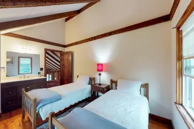 two beds in a room with a sink and a window at Sunderland Guest House in Manchester
