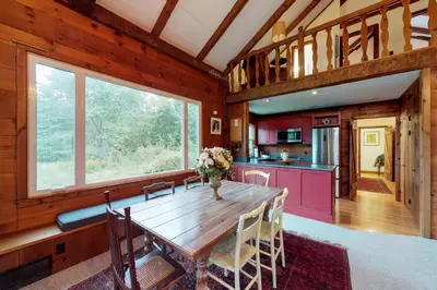 a kitchen with a wooden table and a large window at Sunderland Guest House in Manchester