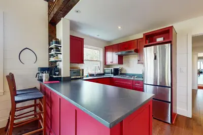 a kitchen with red cabinets and a black counter top at Sunderland Guest House in Manchester