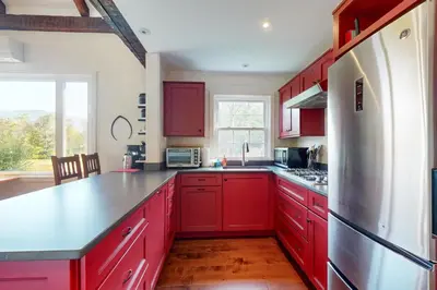 a kitchen with red cabinets and a refrigerator at Sunderland Guest House in Manchester