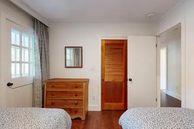 a bedroom with two beds and a dresser and a door at Sunderland Guest House in Manchester