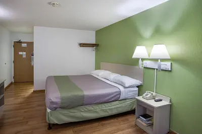 a bedroom with a bed and a green wall at Motel 6-Binghamton, NY in Binghamton