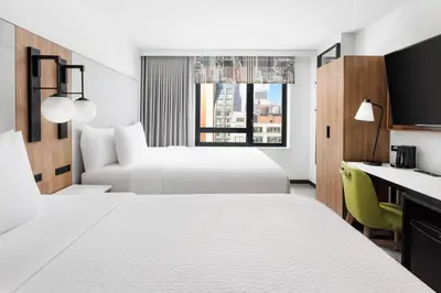 a hotel room with two beds and a desk at Fairfield Inn & Suites by Marriott New York Manhattan/Times Square South in New York