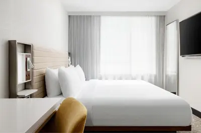 a hotel room with a white bed and a window at SpringHill Suites by Marriott New York Manhattan/Times Square South in New York