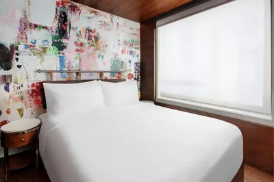 a bedroom with a white bed and a window at SpringHill Suites by Marriott New York Manhattan/Times Square South in New York
