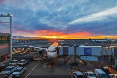 an airplane parked at an airport at sunset at Home2 Suites By Hilton Newark Airport in Newark