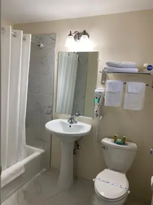 a bathroom with a sink and a toilet and a mirror at Villager Motel in Williamstown