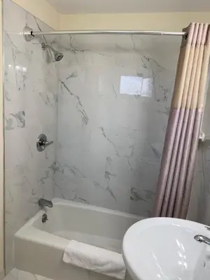 a bathroom with a white tub and a toilet and a sink at Villager Motel in Williamstown