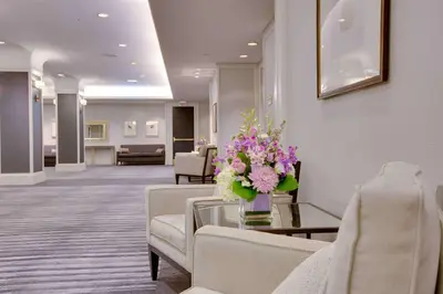 a waiting room with a table with flowers on it at Hilton Newark Airport in Elizabeth