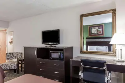 a hotel room with a tv and a mirror at Howard Johnson by Wyndham Newark Airport in Newark