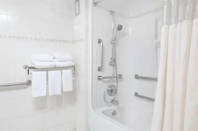 a white bathroom with a shower and a tub at Howard Johnson by Wyndham Newark Airport in Newark