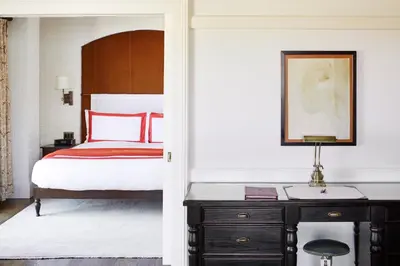 a bedroom with a bed and a desk with a lamp at The Bowery Hotel in New York