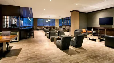 a hotel lobby with chairs and a bar and a television at DoubleTree by Hilton Hotel & Suites Jersey City in Jersey City