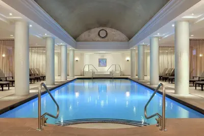 a swimming pool in a hotel lobby with columns at Hilton Short Hills in Short Hills