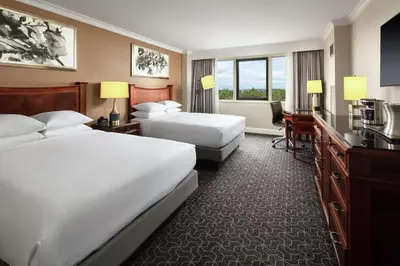 a hotel room with two beds and a desk at Hilton Short Hills in Short Hills